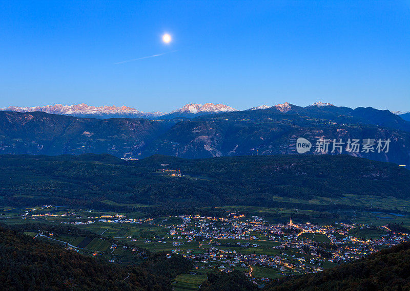 月亮升起在Dolomites与Caldaro / Kaltern村